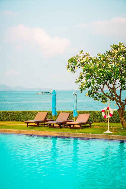 Chair pool and umbrella around swimming pool