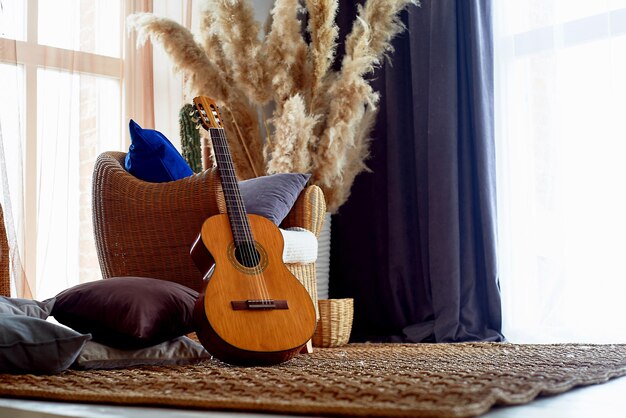 꽃병에 든 등나무 천연 소재 억새로 만든 의자와 깔개Eco design Guitar Hipster Style