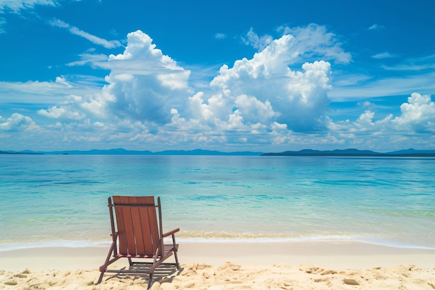 a chair that is on a beach with a sky background