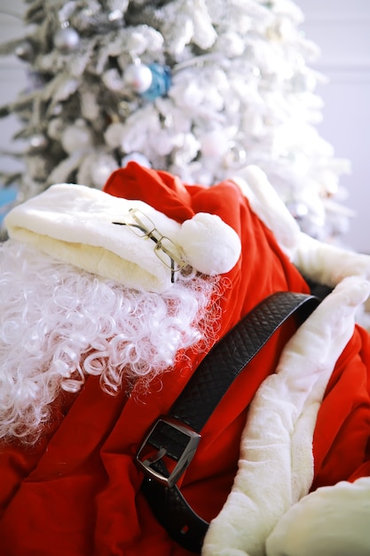 Chair with clothes from Santa Claus. Santa costume hanging in white room