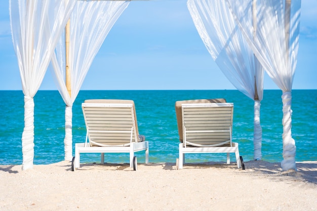 Chairs on beach against blue sky