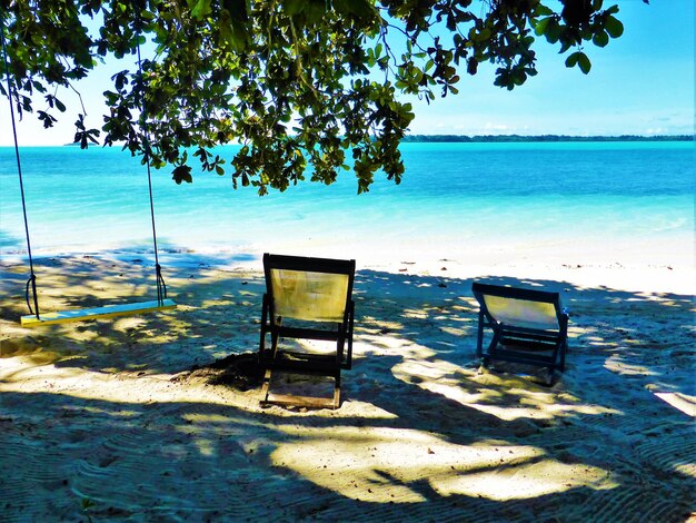 Chairs on beach against sky