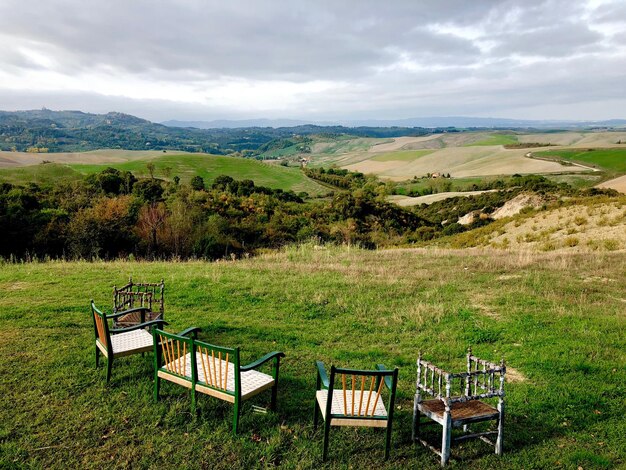 Chairs on field against sky