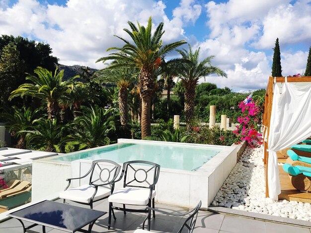 Foto sedie e tavolo vicino alla piscina contro il cielo