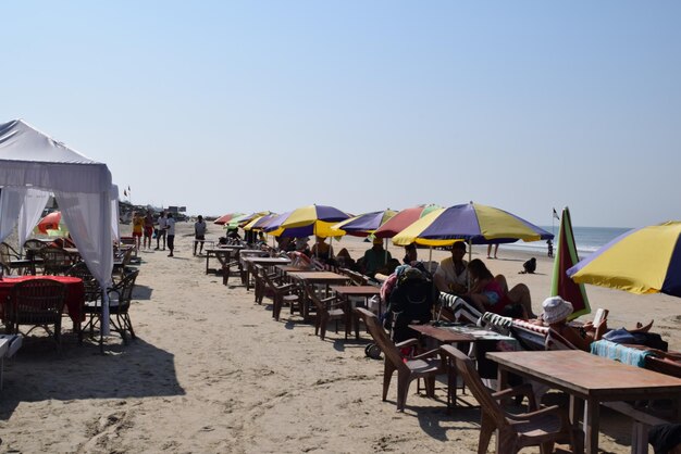 Chairs and tables on beach against clear sky