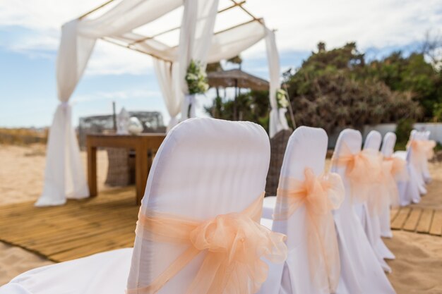 Chairs with bows at the wedding ceremony. Close-up.