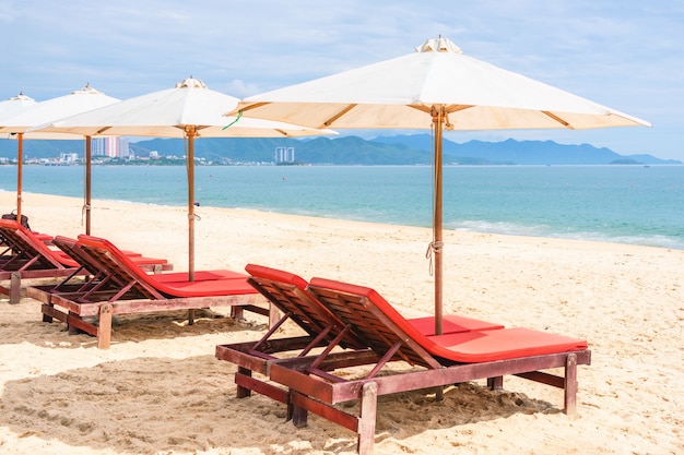 Chairs with umbrella at the empty sea beach. Beach with no travellers and tourists. Vietnam, Nha Trang