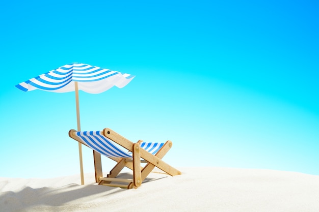 A chaise longue under an umbrella on the sandy beach