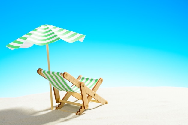 A chaise longue under an umbrella on the sandy beach