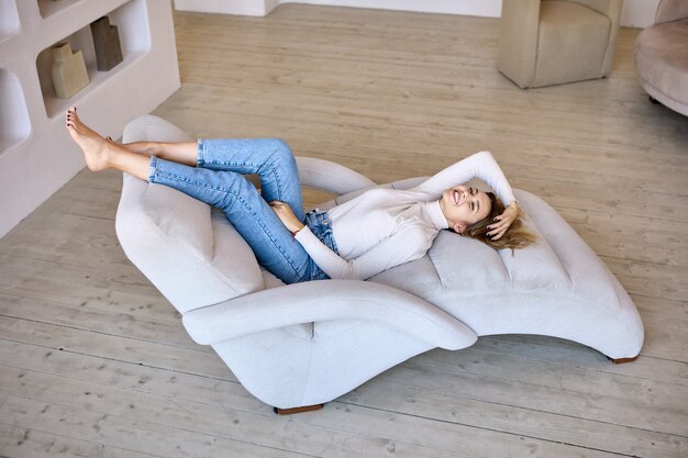 Chaise lounge in living room where woman lies