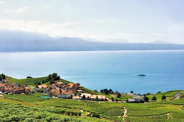 Chalets bij Lavaux Vineyard Terrace-wandelpad en schip op het meer van Genève en de Zwitserse bergen, district Lavaux-Oron, Zwitserland