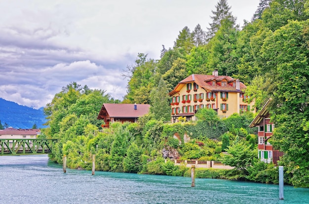 Chalets at Interlaken and Brienz Lake with Swiss Alps in Interlaken Oberhasli district of Bern Canton in Switzerland