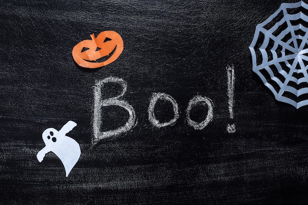 Chalk lettering Boo! on a chalk board with Handmade Halloween decor. Halloween theme