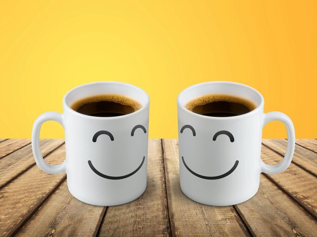 Chalkboard coffee mugs on wooden table with funny cute faces. Friendship day concept