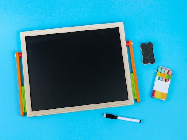 Chalkboard surrounded by accessories on a blue background