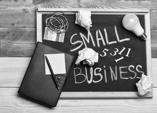 Chalkboard with stationery on wooden background