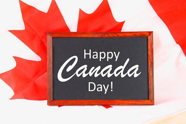 Photo chalkboard with the word happy canada day on the national flag. feast of 1 july.