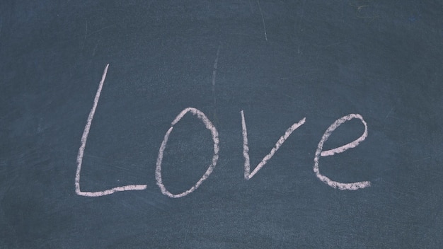 Photo a chalkboard with the word love written in chalk