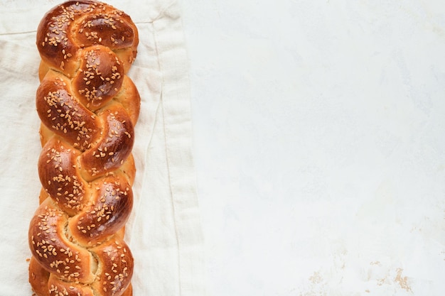 Challah bread Sabbath kiddush ceremony composition Freshly baked homemade braided challah bread for Shabbat and Holidays on white background Shabbat Shalom Top view Copy space