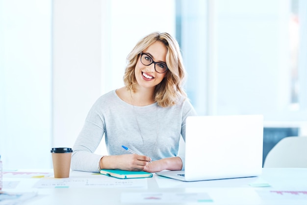 Challenge yourself to do better each day Portrait of an attractive young businesswoman working on a laptop in an office