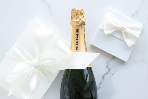 Foto una bottiglia di champagne e una confezione regalo su marmo