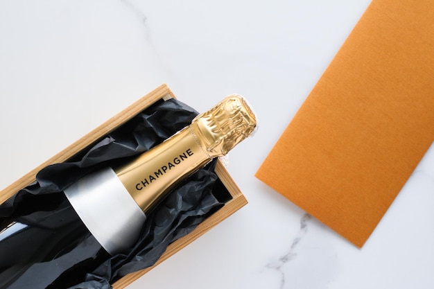 A champagne bottle and a gift box on marble