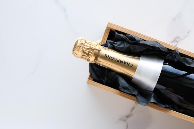 Foto una bottiglia di champagne e una confezione regalo su marmo
