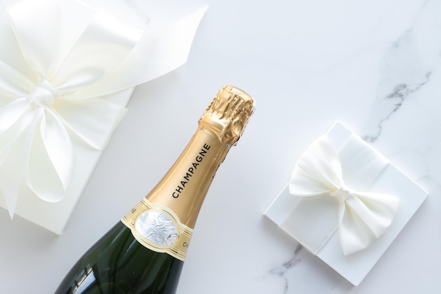 Foto una bottiglia di champagne e una confezione regalo su marmo