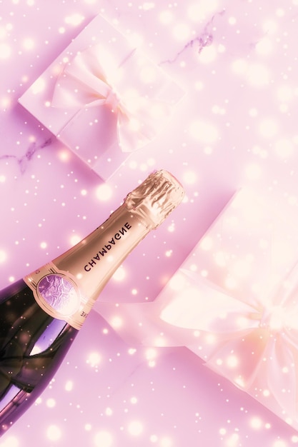 Foto bottiglia di champagne e confezione regalo in vacanza rosa glitter capodanno natale san valentino regalo invernale e confezione di prodotti di lusso per il marchio di bevande