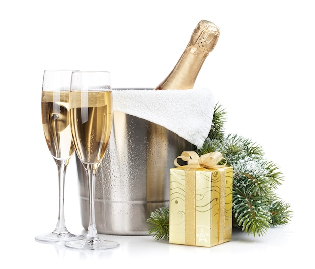 Champagne bottle in ice bucket, two glasses and christmas gift. Isolated on white background