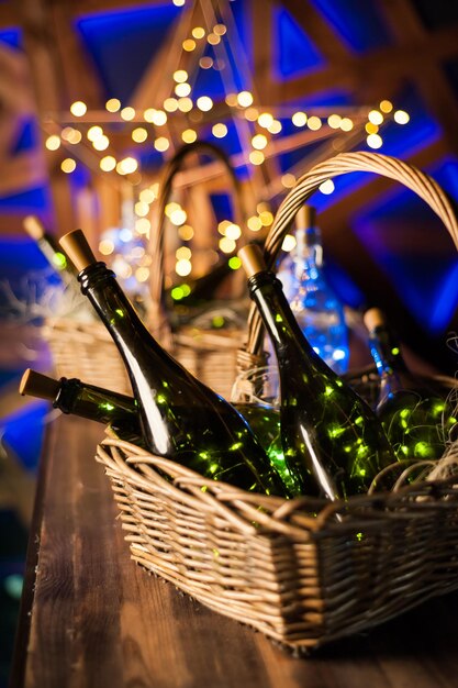 Champagne bottle set with Christmas basket gold garlands on dark brown wooden background new year celebration conceptxA