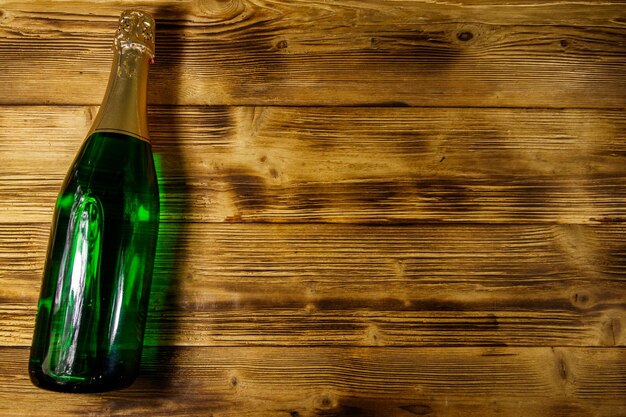 Champagne bottle on wooden background Top view copy space