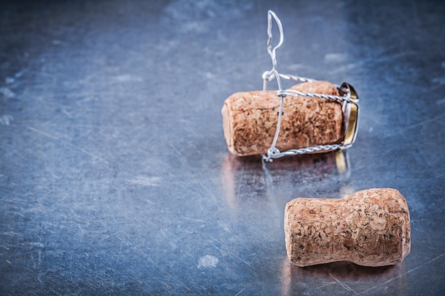 Champagne corks with twisted wires on metallic background