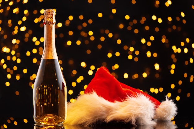 Champagne en kerstman hoed op de achtergrond wazig garland