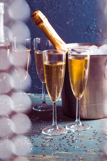 Champagne-fles in emmer met ijs en glazen champagne