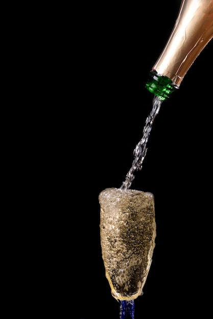 Champagne giet uit fles in een glas