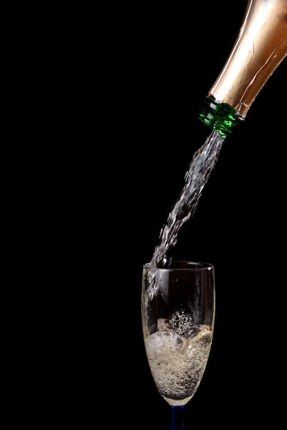 Champagne giet uit fles in een glas