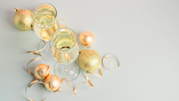 Champagne in glass goblets gold balloons stars serpentine a pastel delicate pink background New year christmas concept