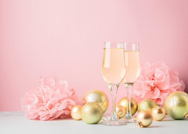 Champagne in glass goblets gold balloons stars serpentine a pastel delicate pink background New year festive concept