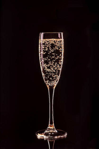 Bicchiere di champagne con bolle con la riflessione