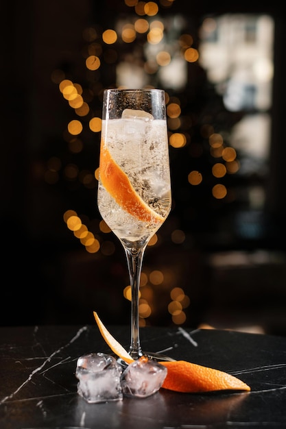 Champagne in a glass with ice and orange zest