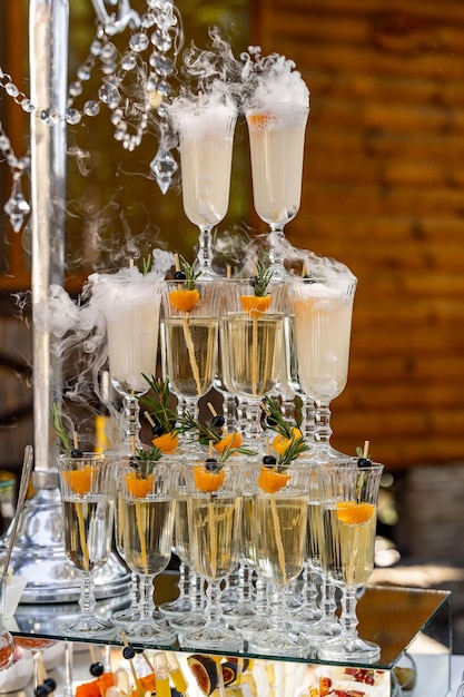 Champagne in the glasses against the wooden background Vertical stand of glasses Close up