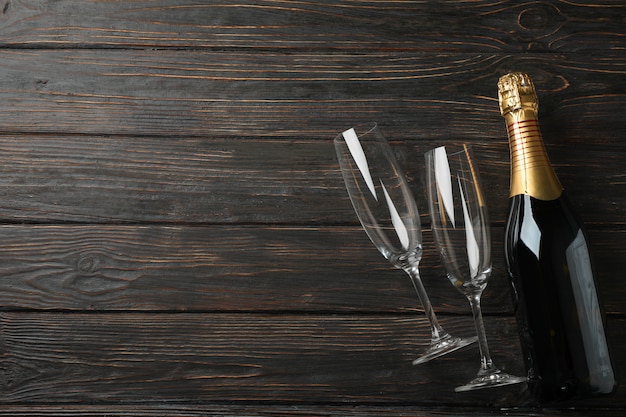 Champagne glasses and bottle on wooden space, space for text