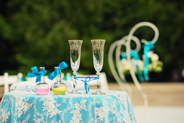 champagne glasses and two bottles with colored sand.