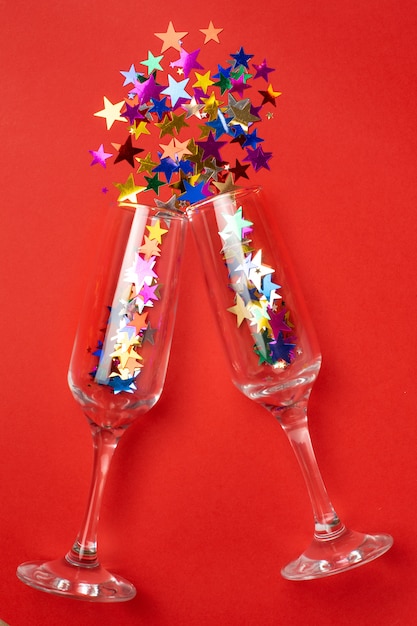 Photo champagne glasses with colored stars confetti