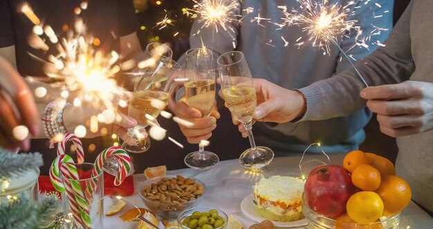 Foto champagne in mano sullo sfondo dell'albero di natale persone focus selettivo albero di natale