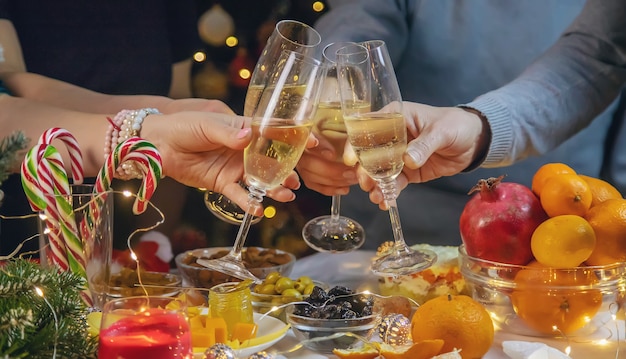 Champagne in mano sullo sfondo dell'albero di natale. persone.