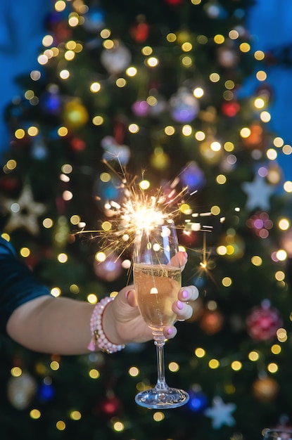 Champagne in hand against the Christmas tree