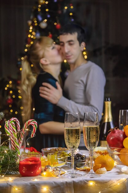 Foto champagne in de hand tegen de achtergrond van de kerstboom. mensen. selectieve aandacht. vakantie.