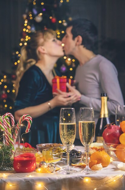 Champagne in de hand tegen de achtergrond van de kerstboom. Mensen.